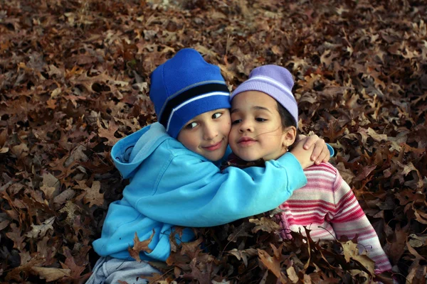 Twee kinderen in bladeren — Stockfoto