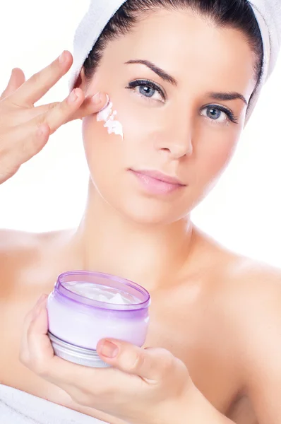 Mooie vrouwen toepassing moisturizer cosmetische crème op gezicht — Stockfoto