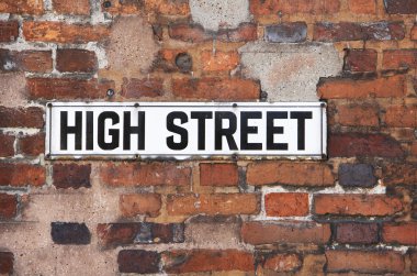 Rusty Metal High Street Road Sign On Brick Wall clipart