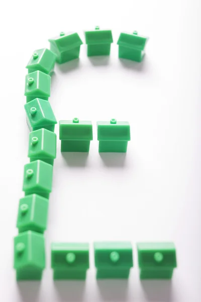 Casas modelo verde em forma de símbolo de libra esterlina — Fotografia de Stock