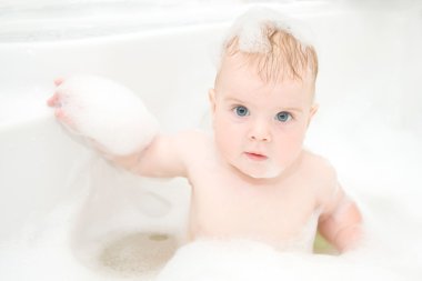 Child washing in bathroom in foam. clipart