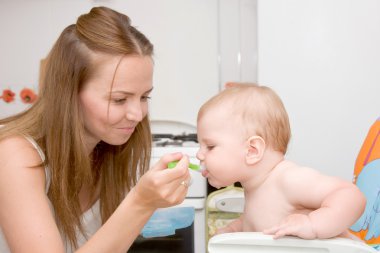 Mother feeding baby clipart