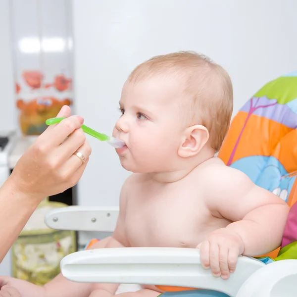 Şirin bebek çocuk ağzına kaşık ile — Stok fotoğraf
