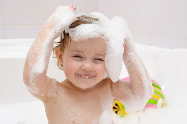 Μικρό παιδί πλύσιμο τα μαλλιά στο μπάνιο Royalty Free Εικόνες Αρχείου