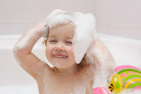 Küçük bir çocuk banyoda saç yıkıyor — Stok fotoğraf
