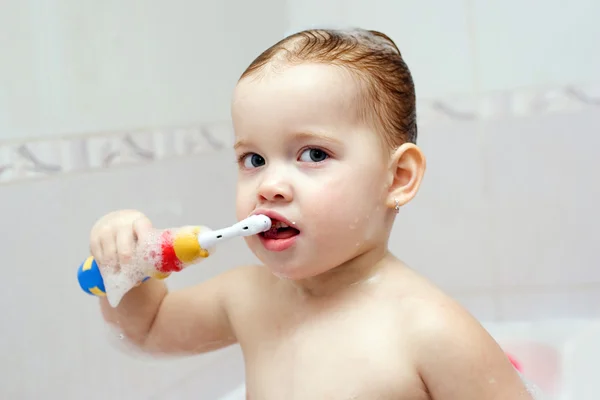 Little child is brushing her teeth in bath — Stock Photo, Image