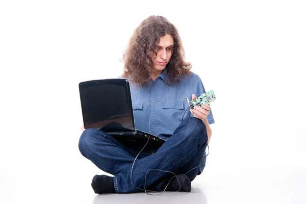 Muž s dlouhými vlasy se dívá na kartě počítače — Stock fotografie