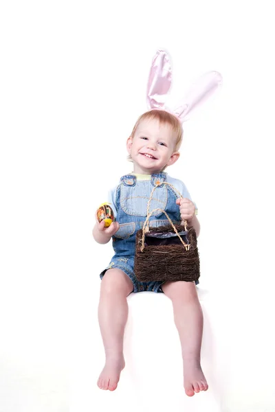 ウサギの耳を持つ子供がイースターエッグを保持しています。 — ストック写真