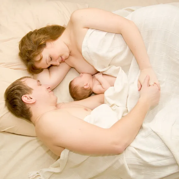 A fehér ágyban alszik együtt szép család. — Stock Fotó