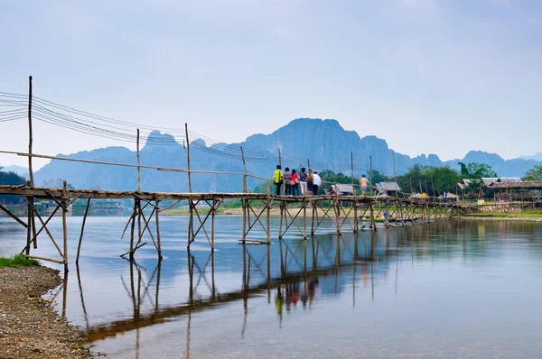 Puente de madera sobre la canción del río a la casa de huéspedes ribereña, Vang vieng, Laos — Foto de Stock