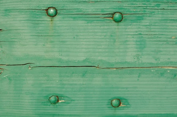 Grüner Holzhintergrund mit vier Schrauben — Stockfoto