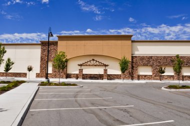 Shopping Center with Paking Lot and Blue Sky clipart