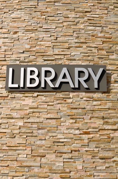 Sinal de biblioteca em uma parede de pedra — Fotografia de Stock