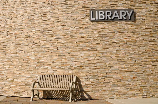 Warten an der Bibliothek mit Schild über Kopf — Stockfoto