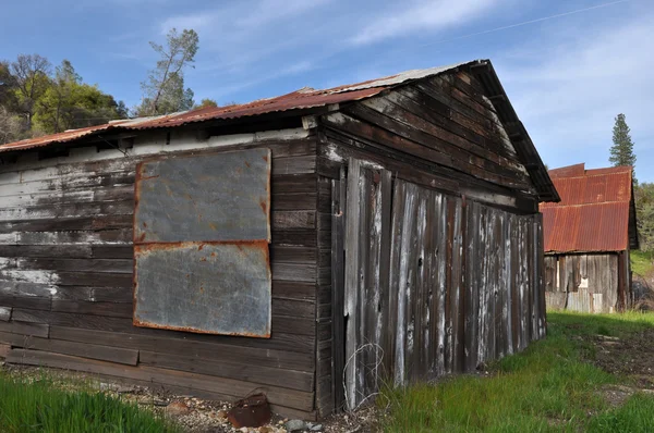 Staré dřevěné kabiny proti modré obloze — Stock fotografie