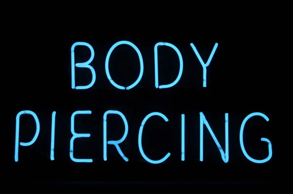 Těla piercing neonový nápis — Stock fotografie