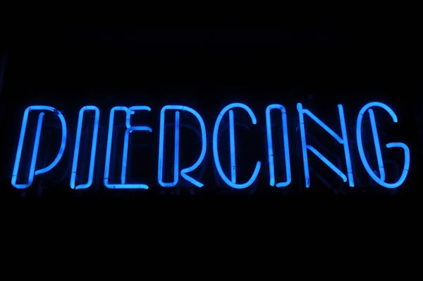 Piercing elektrické modré neonový nápis — Stock fotografie