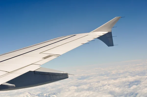 Flugzeugflügel gegen blauen Himmel und Wolken — Stockfoto