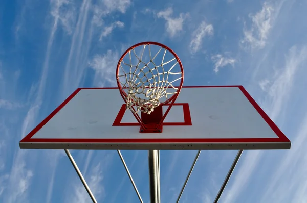 Arco de basquete com nuvens e céu azul — Fotografia de Stock