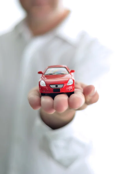 Empresário está segurando carro de brinquedo vermelho — Fotografia de Stock