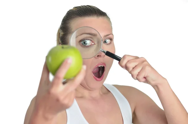 Mulher feliz loira saudável assistindo maçã verde com uma lupa — Fotografia de Stock