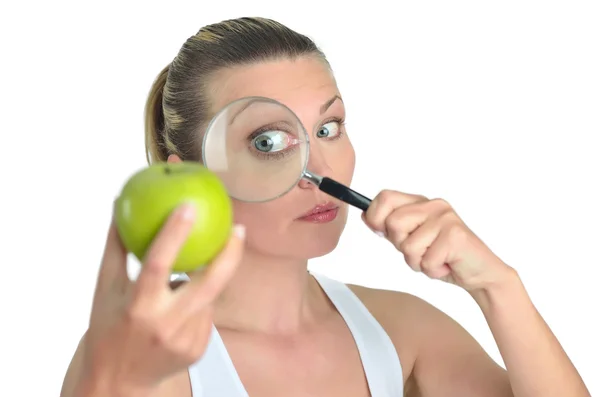 Friska blondy glad kvinna tittar grönt äpple med en magnifyin — Stockfoto