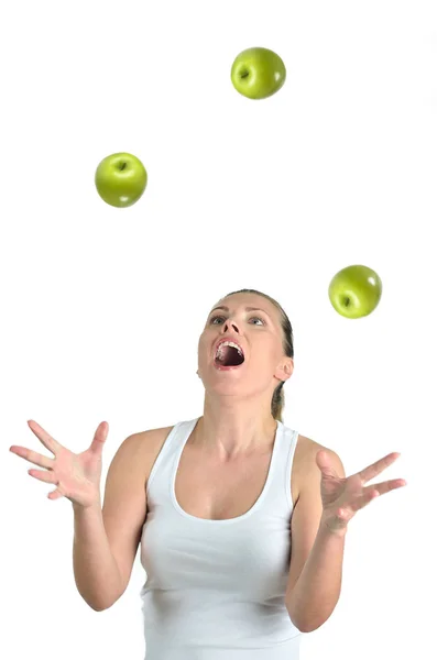 Υγιή όμορφη γυναίκα juggling με πράσινα μήλα στην πλάτη λευκό — Φωτογραφία Αρχείου