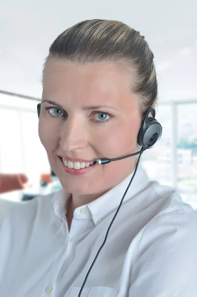 Blondy beautiful girl speaking over the headset — Stock Photo, Image