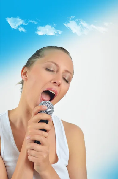 Sexy bella giovane donna che canta con un microfono — Foto Stock