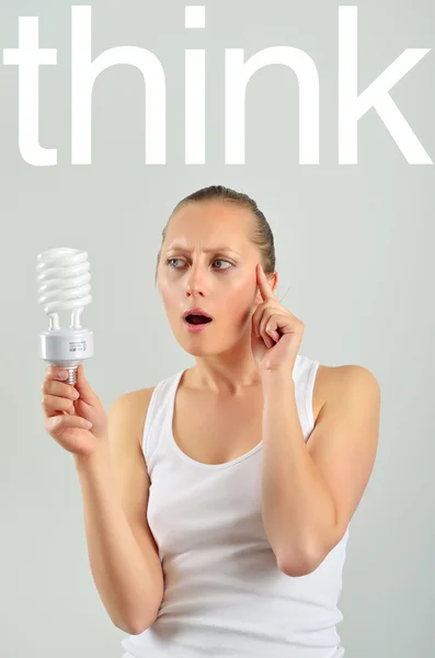 電球を保持するいるとアイデアを持つ美しい若い女性 — ストック写真