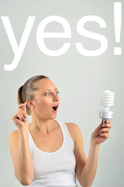 Mooie jonge vrouw met een idee met een bedrijf een lamp — Stockfoto