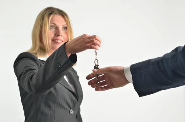 Affärskvinna som håller upp ett par nycklar — Stockfoto