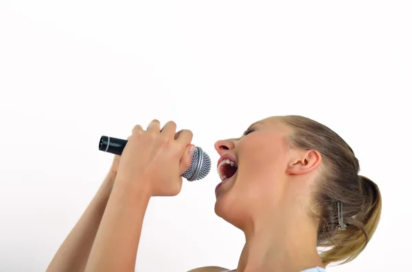 Sexy schöne junge Frau singt mit einem Mikrofon — Stockfoto