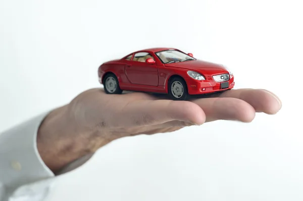 Man die een speelgoedauto op zijn hand — Stockfoto
