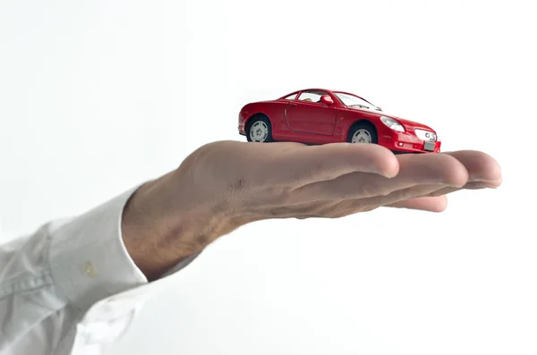 Hombre sosteniendo un coche de juguete en su mano — Foto de Stock