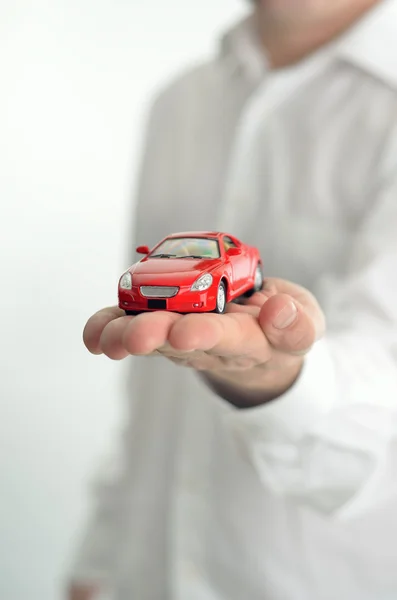 Man med en leksaksbil på handen — Stockfoto