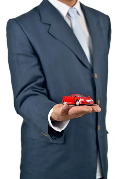 Businessman holding a toy car on his hand — Stock Photo, Image