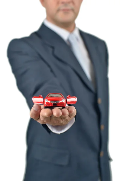 Homme d'affaires tenant une voiture jouet sur sa main — Photo