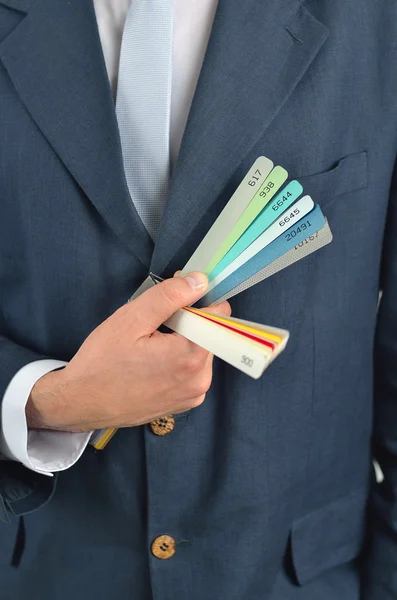 Empresario sosteniendo guía de color aislado en blanco —  Fotos de Stock