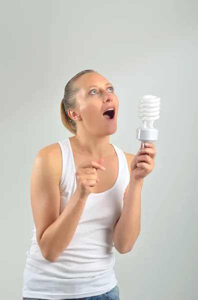 Krásná mladá žena mít dobrý nápad s tím žárovky — Stock fotografie