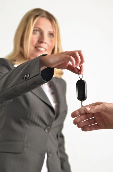 Businesswoman giving keys to businessman — Stock Photo, Image