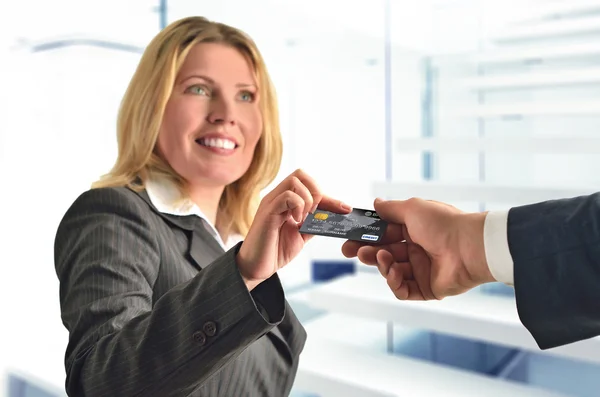 Γυναίκα του ελκυστικού επιχειρηματικού δίνοντας πιστωτική κάρτα σε έναν άνθρωπο — Φωτογραφία Αρχείου
