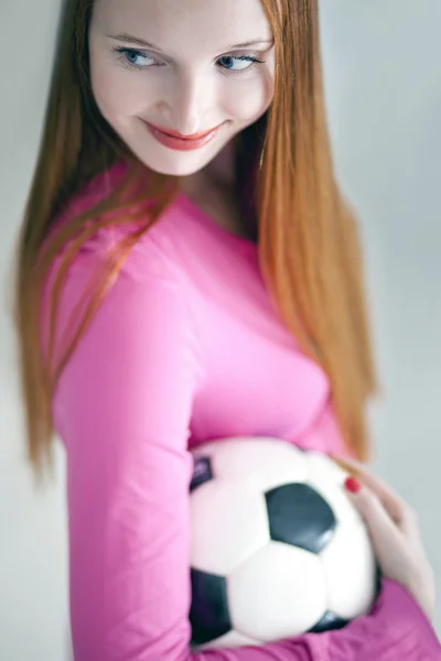 Atractivo pelo largo sosteniendo una pelota de fútbol aislado — Foto de Stock