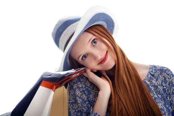 Donna dai capelli lunghi che tiene i sacchetti di carta e indossa un cappello — Foto Stock