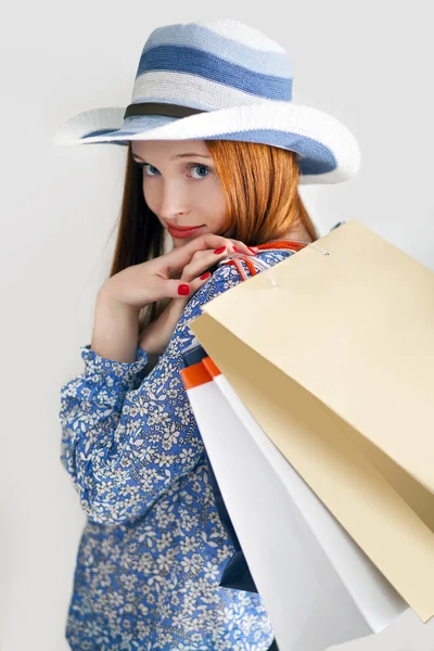 Mujer de pelo largo sosteniendo bolsas de papel y usar un sombrero — Foto de Stock