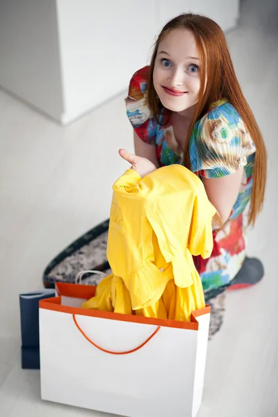 Young girl holding and looking dresses with shopping packages Royalty Free Stock Images