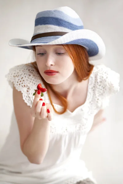 Attraktive schöne langhaarige Frau hält eine Erdbeere — Stockfoto