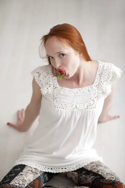 Young beautiful long haired woman eating ripe strawberry — Stock Photo, Image