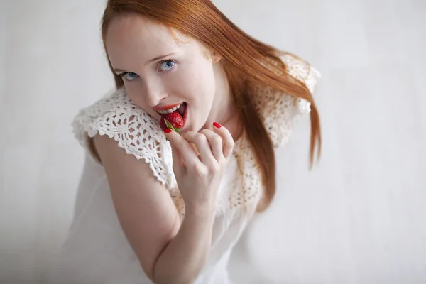 Young beautiful long haired woman eating ripe strawberry — Stock Photo, Image