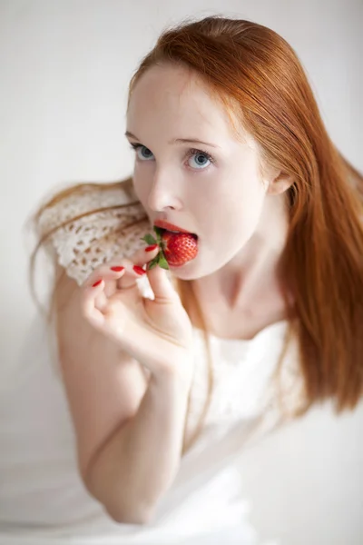 熟したイチゴを食べる若い美しい長い髪の女性 — ストック写真